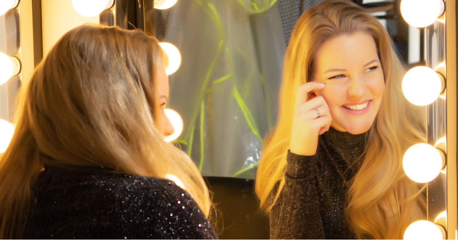 Anna Jois backstage at a lit dressing room mirror