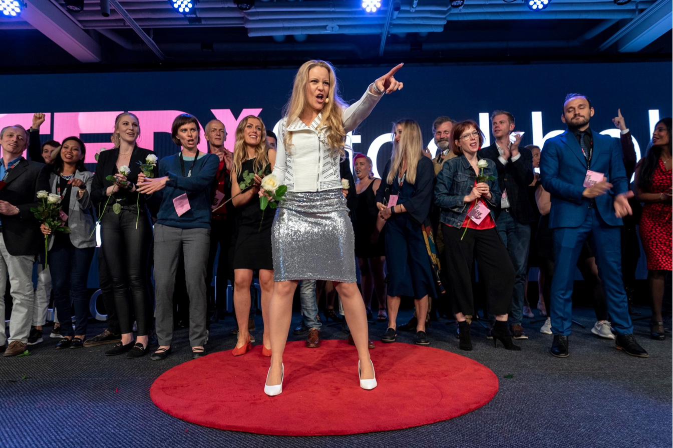 Anna Jois performing with participants on a TEDx stage